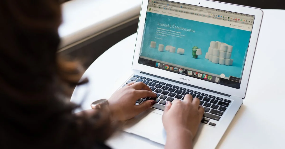 Femme d'affaires travaillant sur un ordinateur portable avec une page web Android 6.0 Marshmallow ouverte.
