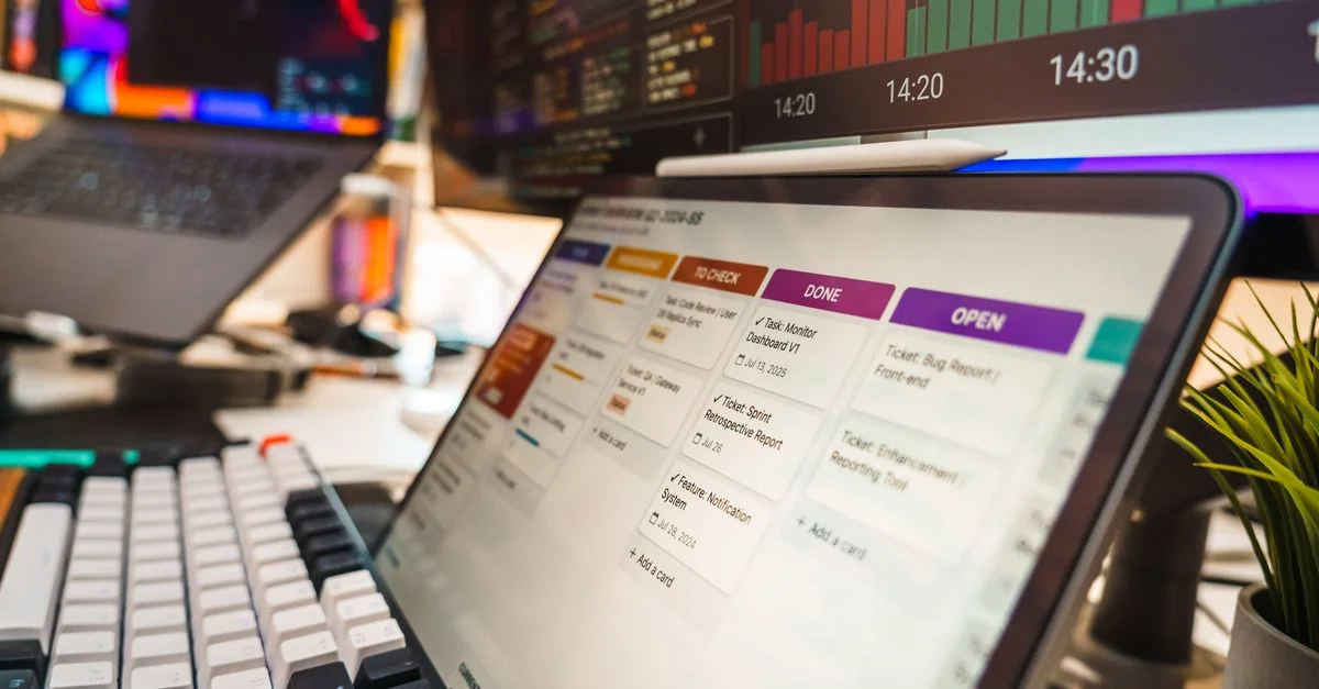 Un aménagement de bureau dynamique comprenant des écrans multiples affichant des graphiques de données et des outils de gestion de projet, idéal pour les environnements technologiques ou commerciaux.