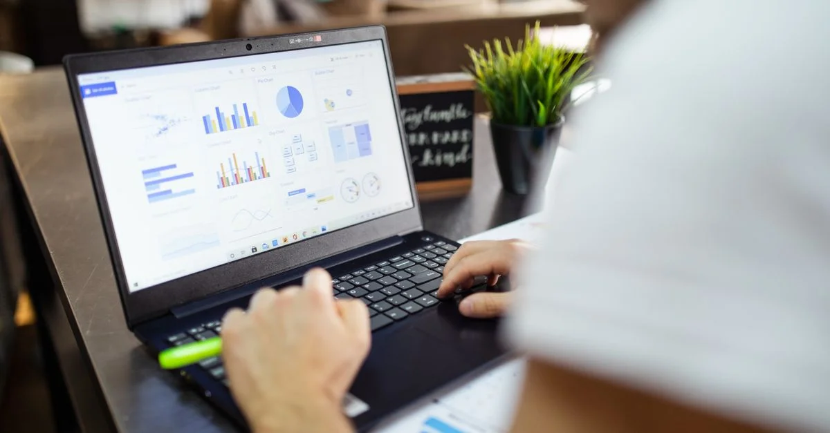 Analyse commerciale concentrée avec des graphiques sur un ordinateur portable dans un bureau moderne.