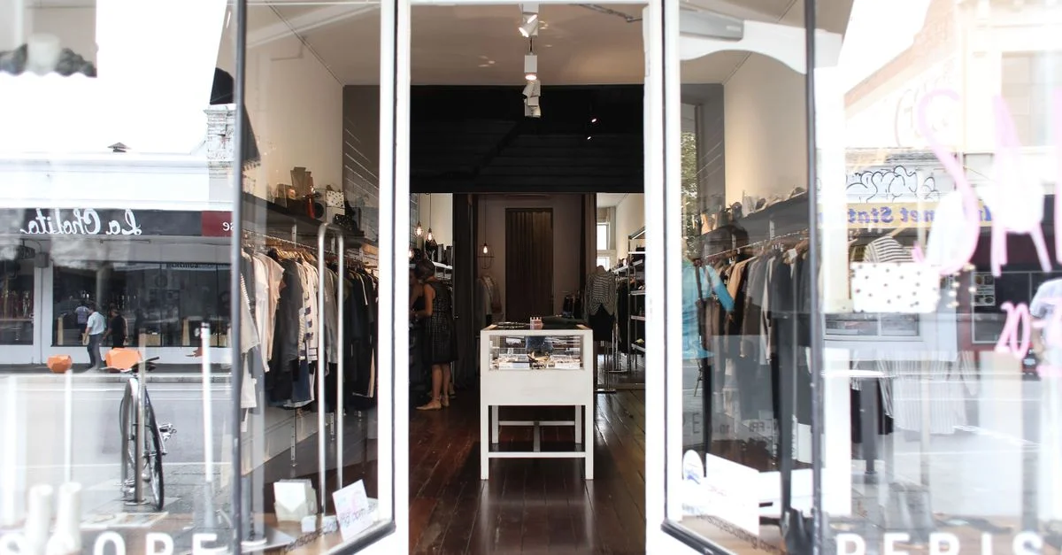 Boutique élégante présentant des vêtements et des accessoires dans un cadre chic et moderne.