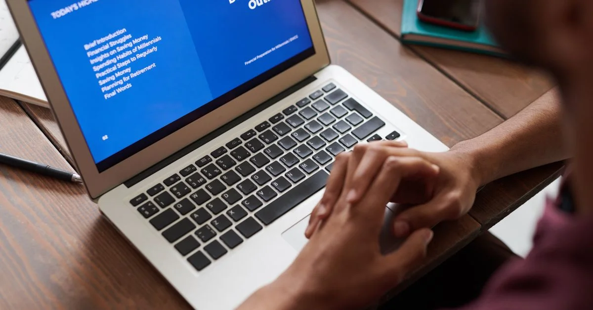 Une personne consultant une présentation professionnelle sur un écran d'ordinateur portable, idéal pour l'apprentissage en ligne et les environnements de travail.